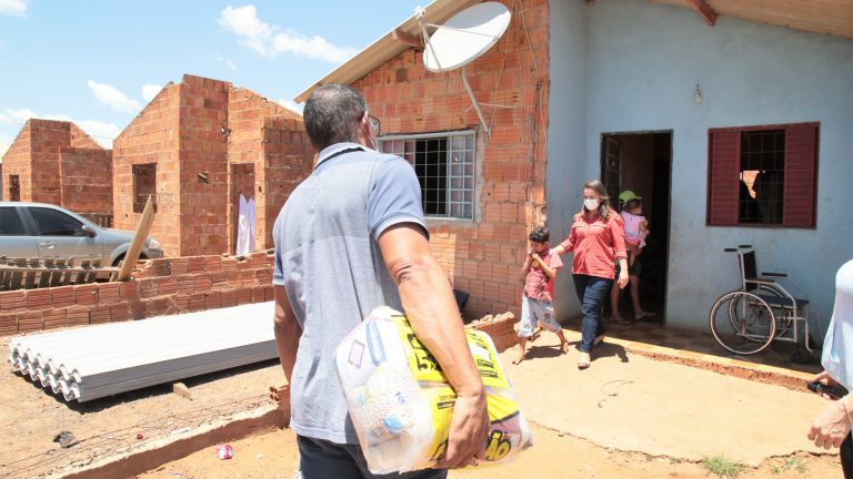 Funcionário da Prefeitura entrega materiais de construção para beneficiados com auxílio