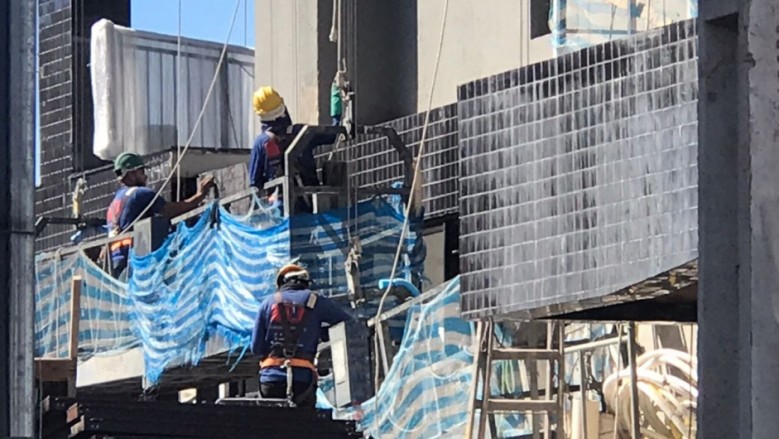 Trabalhadores do setor de Construção Civil devidamente trajados com equipamentos de segurança